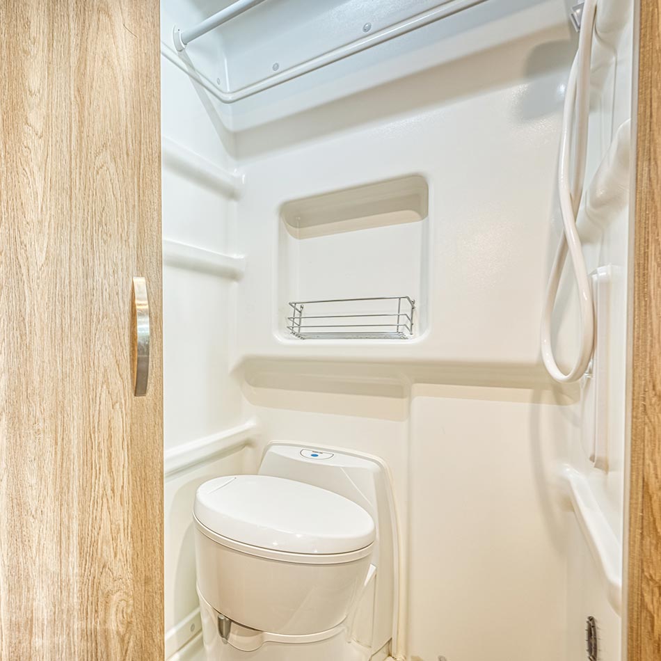 The wet bath, a combination toilet and shower with a wood-clad door